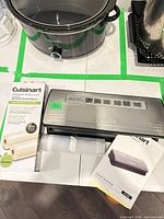 Vacuum sealer with boxed bag rolls, loose roll and manual