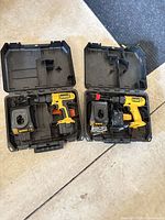 Two open cases showing each drill, charger, battery and bits