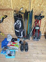 Group shot of entire lot including bag, clubs, cart, umbrellas, shoes, balls, tees