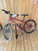 Full view of red Kona Cinder Cone bike with tire pump