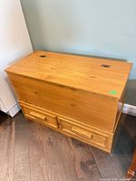 Closed pine blanket box showing lid, exterior grain, hinges, and two drawers