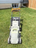 Full view of LawnMaster electric mower on lawn with extension cord wrapped on handle