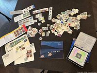 Overview of lot showing loose stamps, first-day covers, stamp panels, booklet, tin