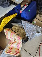 Weighted blanket, reversible coverlet and drapes inside and beside storage bin