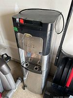 Front view of Whirlpool stainless and black water dispenser showing full unit