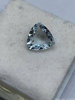 Trillion-cut aquamarine resting on white foam pad