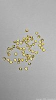 Group of small round lemon yellow sapphires on grey background