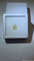 Pear cabochon alexandrite in display box, top view showing cat’s-eye line
