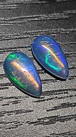Pair of pear-shaped opal cabochons showing play-of-colour