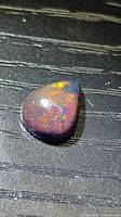 Top view of pear cabochon opal showing multicolour play