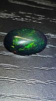 Top view of oval Ethiopian black opal showing play of color