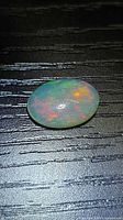 Top view of the oval opal showing multicolored play-of-color
