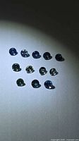 Front view of all 12 multicolored sapphires under light