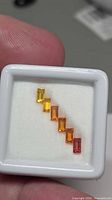 Diagonal arrangement of six baguette sapphires in display box