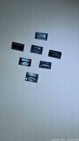 Seven rectangular blue sapphires arranged on white background
