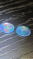 Both oval cabochon opals showing multicolored play of color