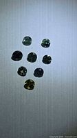 Eight round multicolored sapphires on light background