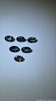 Six oval faceted sapphires on light background, showing colour mix