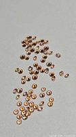 Scattered view of small round orange sapphires on neutral background