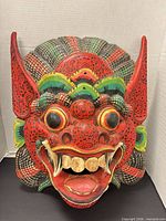 Full front view of the painted wooden Barong mask