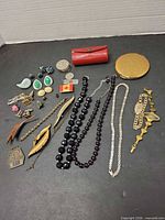 Full layout of jewellery, tokens, compact and lipstick case