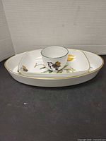 Deep oval Evesham dish and small bowl showing fruit motifs and gold rim