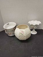 Group shot showing Belleek bowl, footed bowl and stack of five small bowls