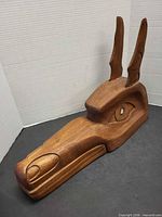 Full view of cedar wolf carving showing head, snout, and upright ears