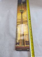 Front cover of brochure beside measuring tape showing length