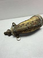 Full view of powder horn showing brass fittings, studs, suspension rings