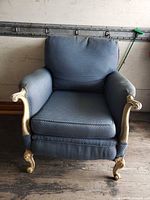 Front view of blue fabric armchair showing seat and carved legs