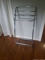 Front view showing three towel bars and wire shelf