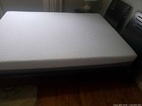 Full view of mattress on bed frame showing queen size and surface condition