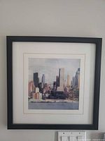 Full view of framed cityscape print on wall