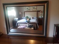 Front view of large wood framed mirror