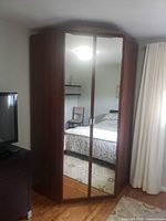 Corner wardrobe showing mirrored double doors and corner fit
