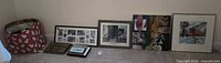 Group of assorted frames and prints leaning against wall