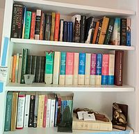 Full bookcase view showing Dickens set, top and bottom shelves of assorted modern titles