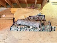 Stacked rugs, foam rolls and pad in attic space