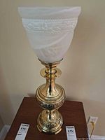 Full view of brass-plated table lamp with shade off