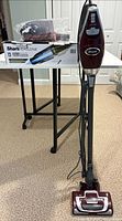 Upright vacuum standing; Shark Cyclone box and handheld visible