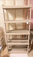 Front view of assembled 5-shelf tan plastic storage unit