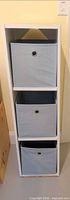 Full view of white cube storage shelf with three fabric bins inserted