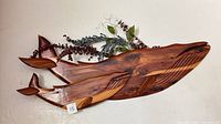 Front view of cedar whale sculpture showing grain and greenery