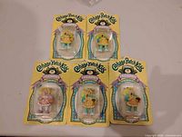 Five sealed Cabbage Patch Kids figurines on cards laid out