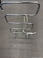Front view of S-shaped chrome heated towel rack with cord and feet