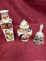 Front view of vase, ginger jar and bell showing overall form and decoration