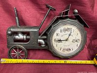 Full view of metal tractor clock with tape measure showing length