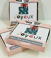 Three sealed packs of square holiday coasters showing packaging front and size info