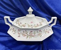 Tureen front view showing floral ribbon design and handles